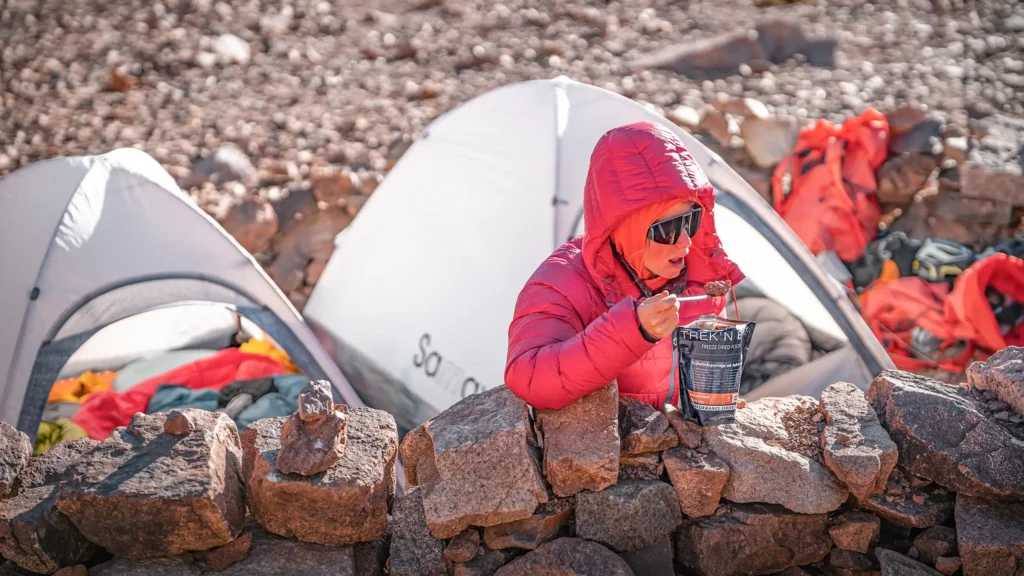 Rea Kolbl eating a freeze-dried meal at a high-altitude camp Cerro Mercedario